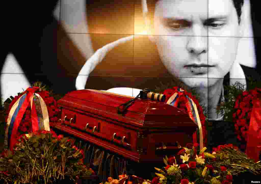 A coffin with the body of Russian photojournalist Andrei Stenin is seen on stage during a memorial service in Moscow, Sept. 5, 2014.