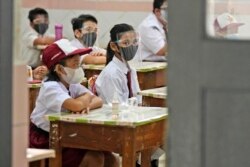 Siswa yang memakai masker saat mengikuti pelajaran hari pertama pembukaan kembali sekolah di sebuah sekolah dasar di Jakarta, Senin, 30 Agustus 2021. (Foto: AP)