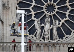 Firefighters work near the rose window of Notre Dame cathedral, Apr. 16, 2019 in Paris.