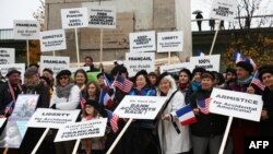 FILE - A protest organized by the Accidental Americans Association to alert the U.S. president on their situation, as he is in Paris to attend World War I armistice centenary commemorations, at the base of the Paris Statue of Liberty, Nov. 11, 2018.