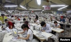 FILE - Laborers work at a garment factory in Bac Giang province, near Hanoi, Oct. 21, 2015. Vietnam's textiles and footwear would gain strongly from the Trans-Pacific Partnership, after exports of $31 billion last year for brands such as Nike, Adidas and H&M.