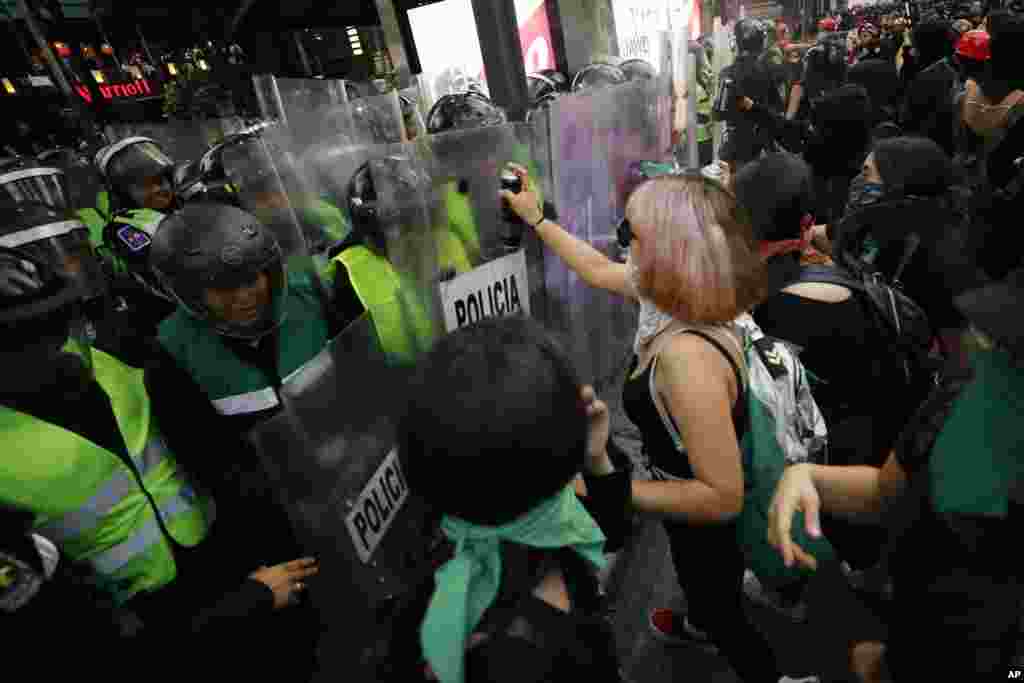 Activistas acusan a la policía antidisturbios durante una marcha en protesta por la violencia contra las mujeres en la Ciudad de México.