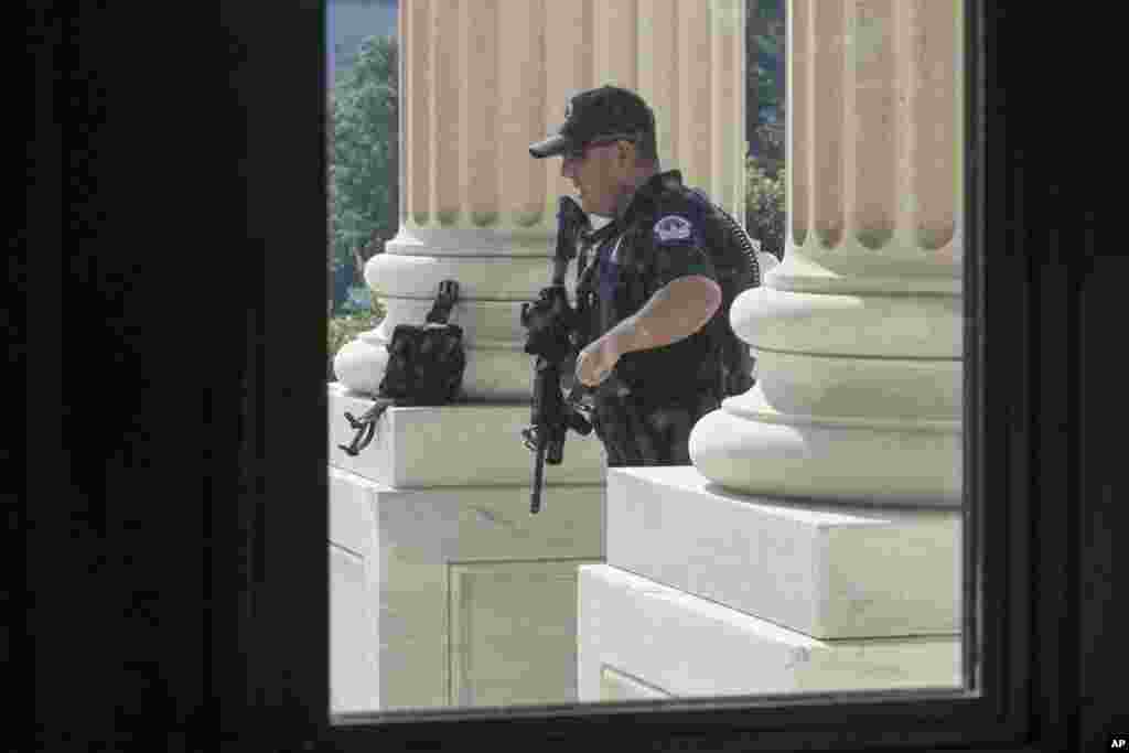Yon polis nan Capitol Hill la kap fè pòs devan Chanm Reprezantan an, Capitol Hill nan Washington, 14 jen 2017.