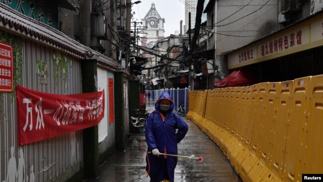 Un miembro de las autoridades sanitarias de Wuhan fumiga una de las calles de la ciudad.