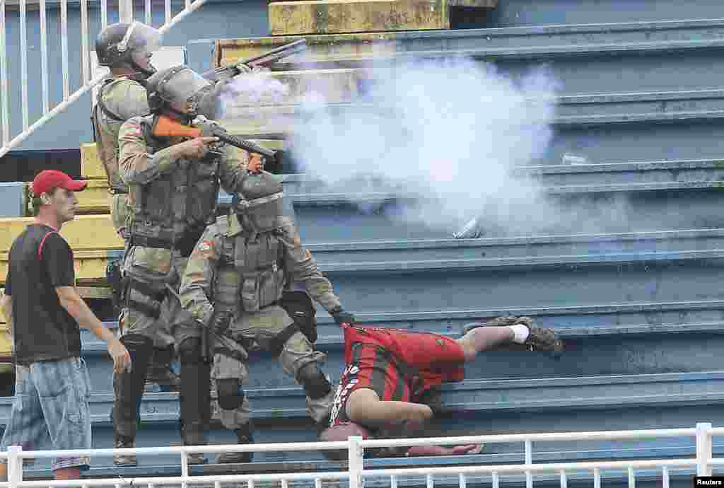Policemen fire rubber bullets during clashes between Vasco da Gama soccer fans and Atletico Paranaense fans at their Brazilian championship match in Joinville in Santa Catarina state, Dec. 8, 2013.