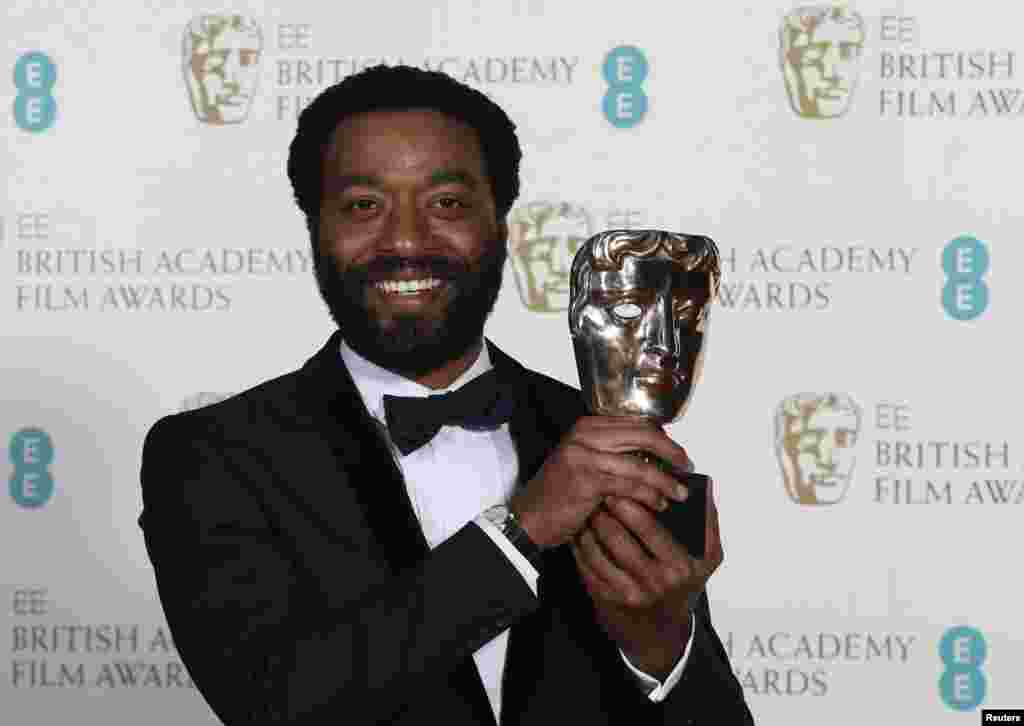 O actor Chiwetel Ejiofor com a estatueta de Melhor Actor em "12 Anos Escravo" dos Prémios BAFTA da Academia Britânica de Artes e Cinema, na cerimónia na Royal Opera House em Londres Fev. 16, 2014. REUTERS/Suzanne Plunkett