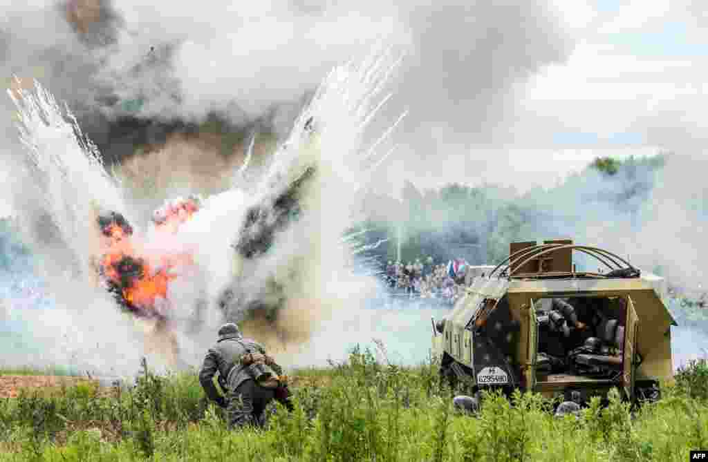 Military history enthusiasts dressed as Nazi Germany&#39;s troops take part in a stage battle &quot;Summer 1941&quot; near the village of Ivanovskoye, some 60 km outside Moscow, Russia, during &quot;War of Motors 2014&quot; festival marking 73d anniversary of the Nazi invasion of the Soviet Union.