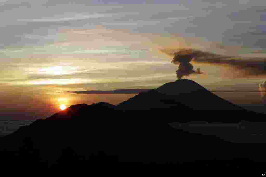 تصویری از دود برآمده از کوه آتشفشان به هنگام غروب آفتاب در بالی اندونزی