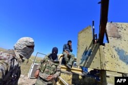 Fighters with the Syrian Democratic Forces (SDF) gather near the village of Baghuz, Syria, March 20, 2019.