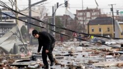 Una mujer recupera un objeto de una casa destrozada, el martes 3 de marzo de 2020, cerca de Lebanon, Tennessee, luego del paso de unos tornados. (AP Foto/Mark Humphrey)