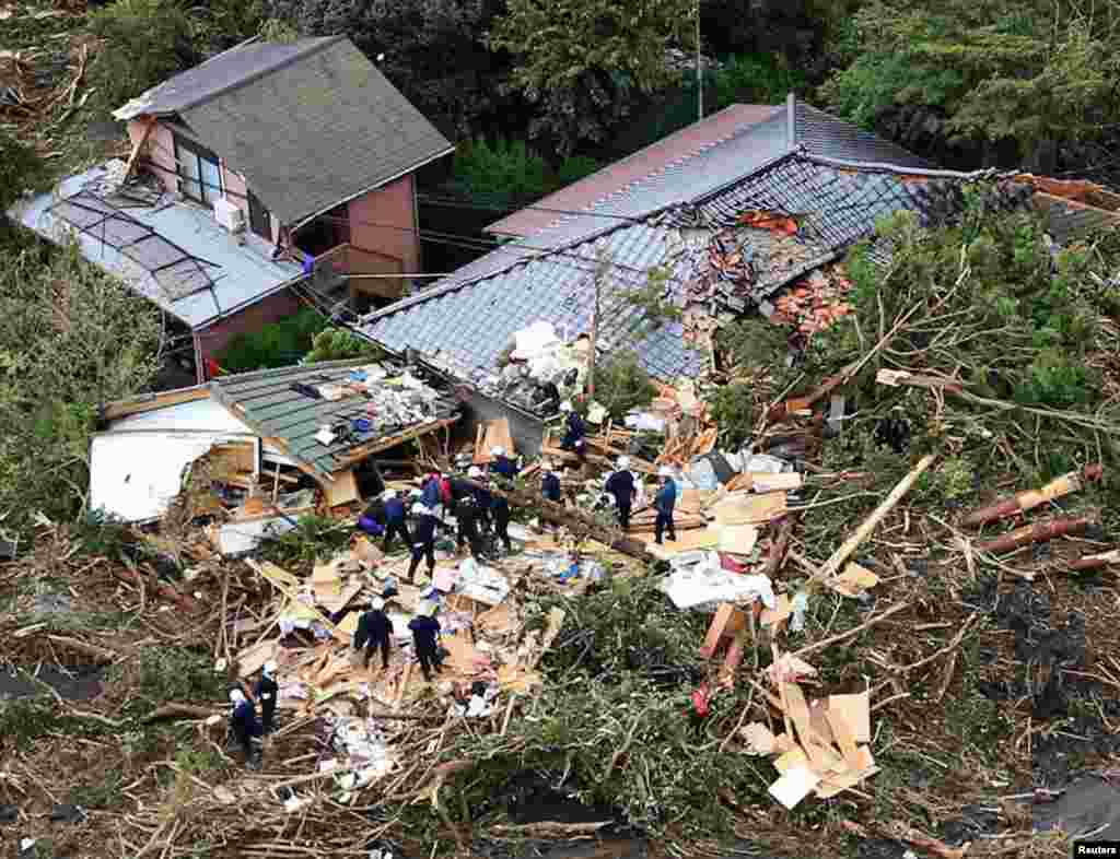 Foto udara menunjukkan petugas penyelamat mencari korban di antara reruntuhan rumah yang ambruk menyusul longsor akibat Topan Wipha di pulau Oshima Izu, selatan Tokyo.