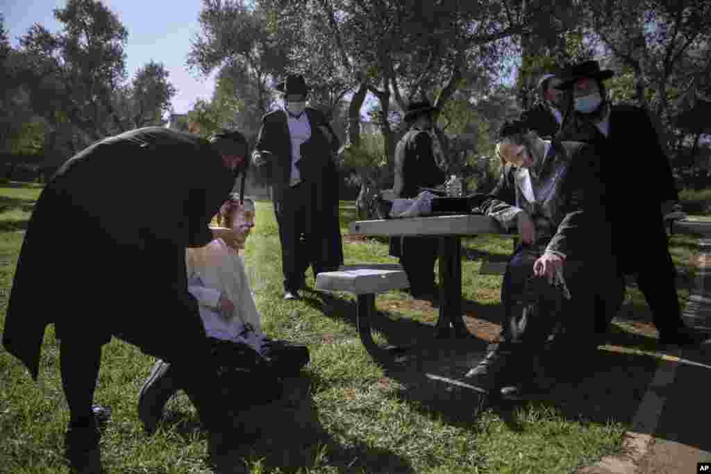 Ultra-Orthodox Jewish men are covered with flour after being pepper sprayed by security guards during a protest against the construction of a hotel at a site that protesters claim contains ancient graves, in Jerusalem.