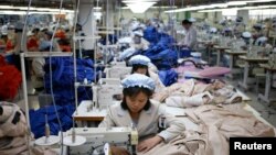 FILE - North Korean employees sew in a South Korean-owned company at the Kaesong industrial park just north of the demilitarized zone, December 2013.