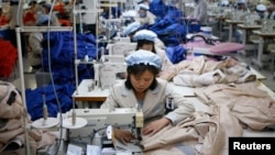 FILE - North Korean employees, shown in December 2013, sew in a South Korean-owned company at the Kaesong industrial park just north of the demilitarized zone. 