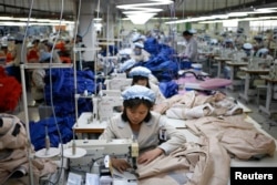 FILE - North Korean employees, shown in December 2013, sew in a South Korean-owned company at the Kaesong industrial park just north of the demilitarized zone.