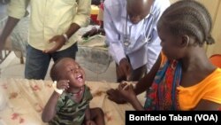 Dr. James Peter consults with Nyayub Kuol, who has brought her two-year-old son to Bentiu hospital for treatment for malaria. Unity state has seen a spike in the number of cases of malaria and Kala Azar, also called visceral leishmaniasis, especially among children. (VOA/Bonifacio Taban) 