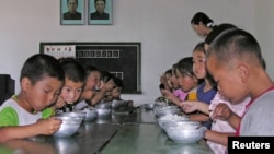 Trẻ em Bắc Triều Tiên ăn trưa tại trường mẫu giáo nhà nước ở quận Taedong, ở phía nam tỉnh Pyongan, Bắc Triều Tiên, ngày 18/7/2005. 
