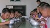 FILE - North Korean children eat lunch at a government-run kindergarten in Taedong county in south Pyongan province, July 18, 2005.
