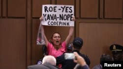 A protester is removed during the start of U.S. Supreme Court nominee judge Brett Kavanaugh's Senate Judiciary Committee confirmation hearing on Capitol Hill in Washington, Sept. 4, 2018.
