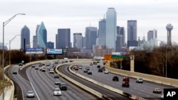 This Friday, Jan. 14, 2011, file photo shows highway traffic with the Dallas skyline in the background. (AP Photo/Tony Gutierrez, File)