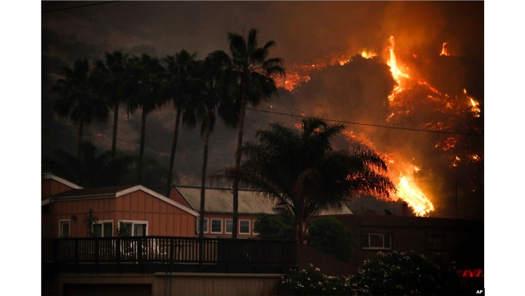 A wildfire threatens homes as it burns along a hillside in La Conchita, California, Dec. 7, 2017.