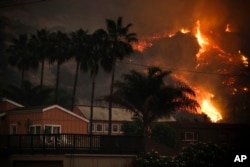 A wildfire threatens homes as it burns along a hillside in La Conchita, California, Dec. 7, 2017.