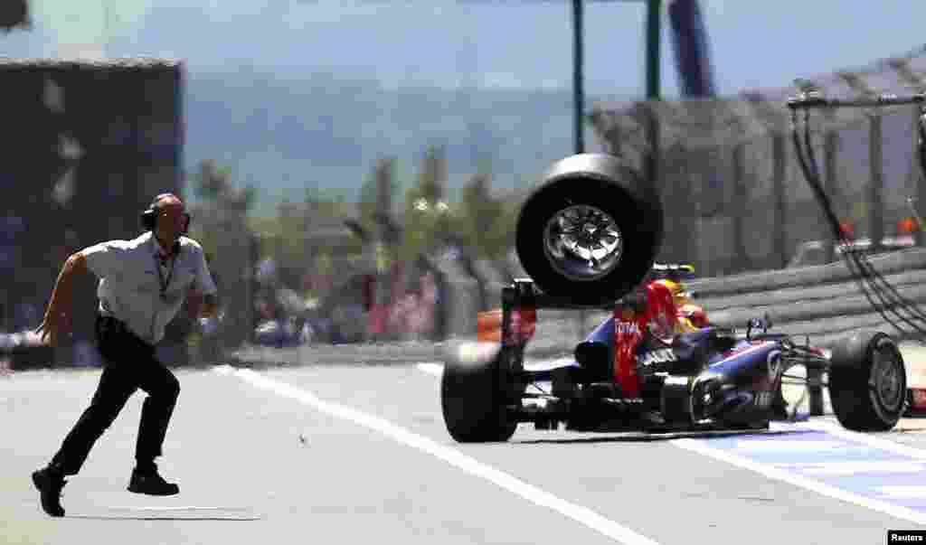 An unidentified FIA official runs over to the pits as a lost rear tire of Red Bull Formula One driver Mark Webber of Australia bounces through the pit lane during the German F1 Grand Prix at the Nuerburgring circuit, Germany.