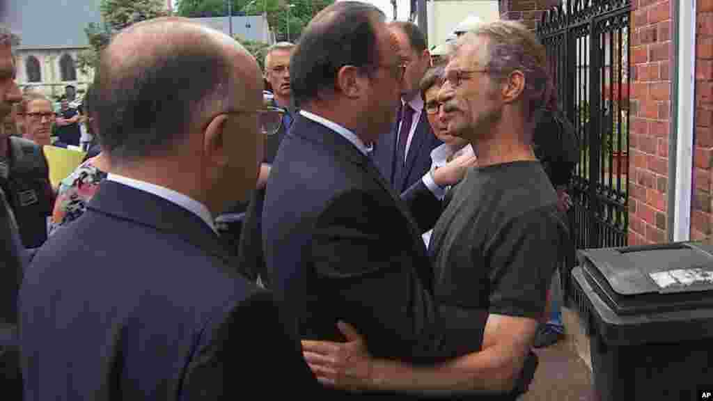 François Hollande, qui s&#39;est rendu sur les lieux, s&#39;entretient avec le maire de la commune normande, Hubert Wulfranc, peu après le drame, le 26 juillet 2016.