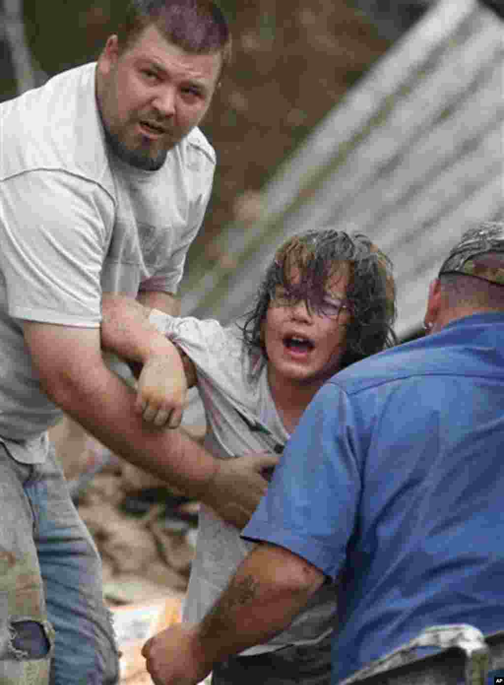 A child calls to his father after being pulled from the rubble of the Tower Plaza Elementary School following a tornado in Moore, Okla., Monday, May 20, 2013. 