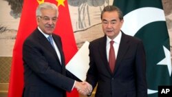 Pakistan's Foreign Minister Khawaja Muhammad Asif, left, and Chinese Foreign Minister Wang Yi shake hands at the end of a joint press conference at the Diaoyutai State Guesthouse in Beijing, Sept. 8, 2017.