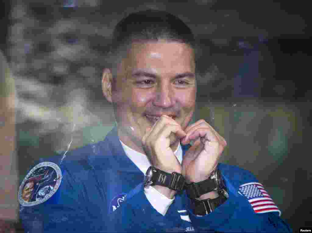 Kjell Lindgren of the U.S., a member of the International Space Station (ISS) crew, gestures to his family from a bus before departure for a final pre-launch preparation at the Baikonur cosmodrome, Kazakhstan, July 22, 2015.