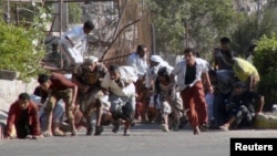 FILE – People run for cover amid gunfire at an army base in Aden, Yemen, March 25, 2015. The U.N. Security Council is meeting to discuss a humanitarian pause in fighting against Houthi rebels.