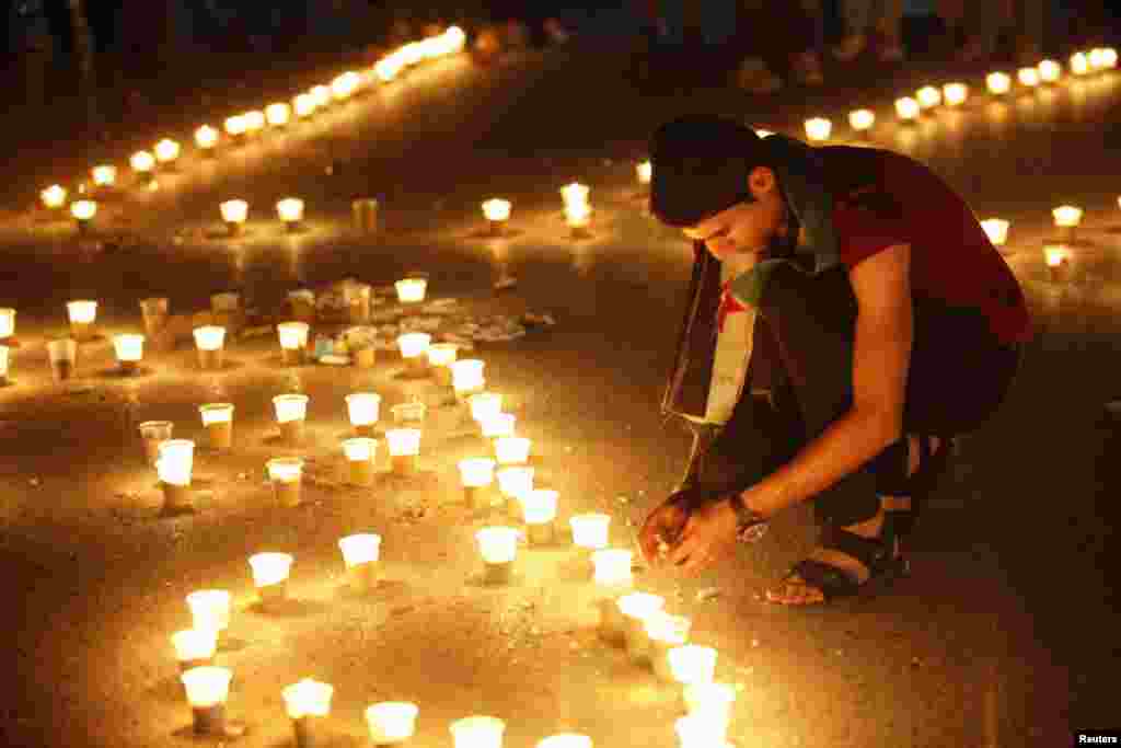 In Raqqa province, a boy lights candles for a sit-in in solidarity with those in Homs, June 4, 2013.