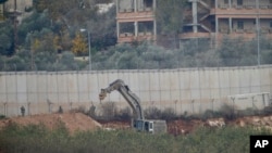 Israeli military digger works on the border with Lebanon in the northern Israeli town of Metula, Tuesday, Dec. 4, 2018. The Israeli military launched an operation on Tuesday to "expose and thwart" tunnels built by Hezbollah it says stretch from Lebanon into northern Israel.