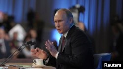 Russian President Vladimir Putin takes part in a televised news conference in Moscow, Dec. 19, 2013. 