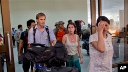 Para staf lokal dan karyawan asing lembaga bantuan non pemerintah tiba dari Siitwe di bandara penerbangan domestik di Rangoon, 28 Maret 2014, menyusul serangan massa Budha di wilayah itu (Foto: dok).