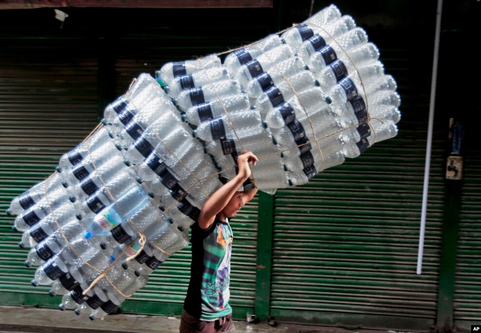 A Bangladeshi boy carry empty bottles on a street in Dhaka, May 21, 2016.