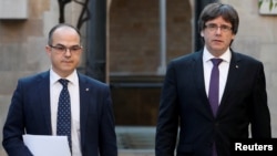 FILE - Catalan President Carles Puigdemont, right, walks with Catalan Government Presidency Councillor Jordi Turull in Barcelona, Spain, Oct. 17, 2017. Catalonia's Parliament votes Thursday for a regional president, and Turell is the third candidate for that post.