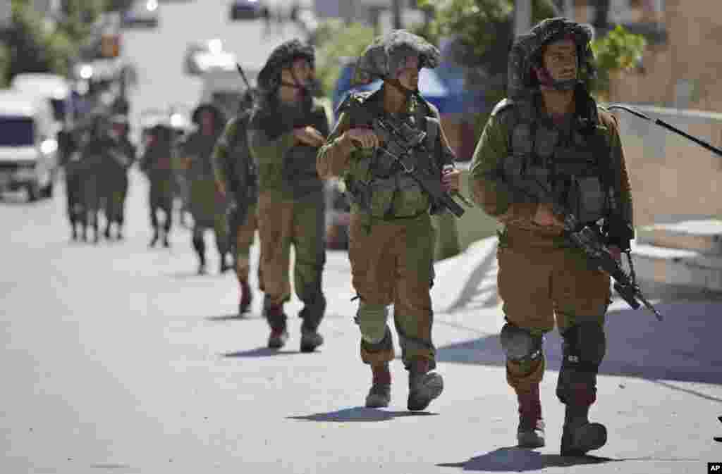 Israeli soldiers patrol during a search for three missing Israeli teenagers in the village of Taffouh near the West Bank city of Hebron, June 18, 2014.