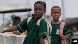 Young Nigerian school girls walk near a bus park. Often girls are forced to give up their educational aspirations (File Photo).