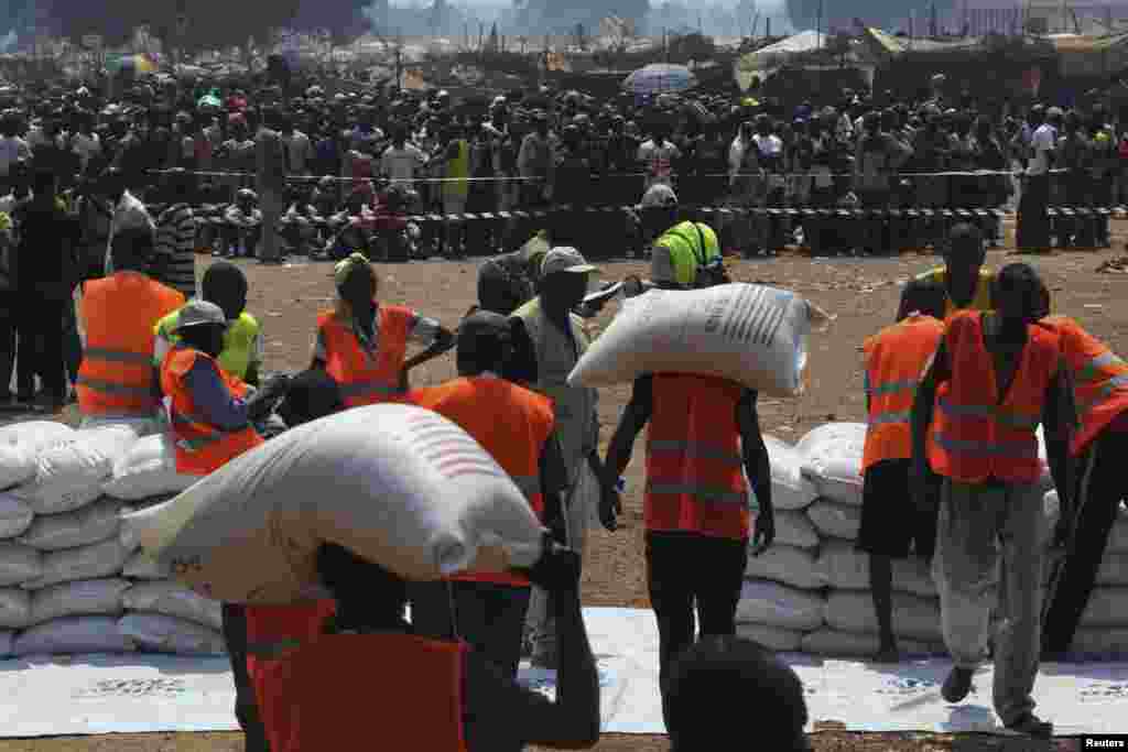 Workers hold rice bags before distribution at the airport in Bangui, Jan. 8, 2014.