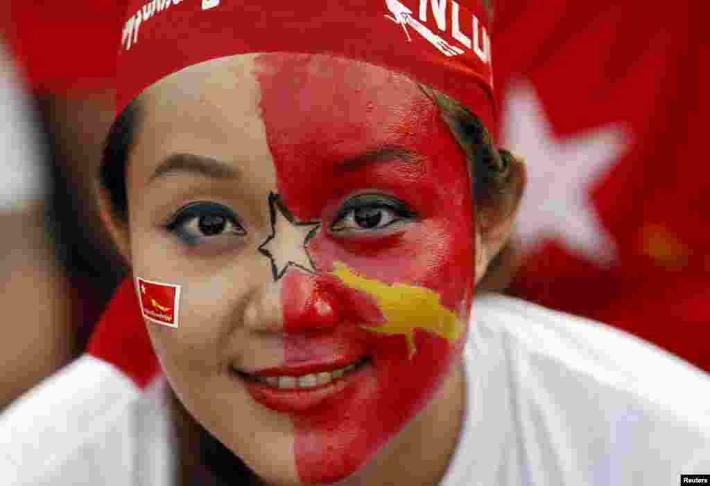 A supporter with face paint smiles during Myanmar pro-democracy leader Aung San Suu Kyi&#39;s speech at a campaign rally for the upcoming general elections in Yangon, Myanmar.