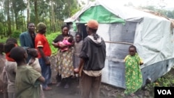 Returnees outside their newly built house in Kimoka village, in North Kivu, eastern DRC, Nov 6, 2015. (VOA/N. Long).