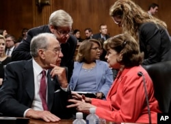 Senator Chuck Grassley, R-Iowa, left, talks with Senator Dianne Feinstein of California at a recent hearing.