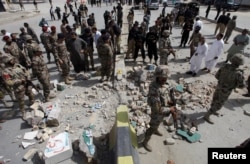 FILE - Security officials gather at the site of a bomb explosion in Quetta, Pakistan, Aug. 11, 2016.