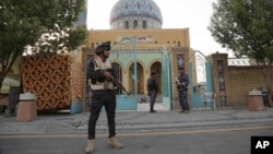 Iraqi security forces stand guard outside a Sunni mosque during the Muslim festival of Eid al-Fitr in Baghdad, Iraq, July 17, 2015. 