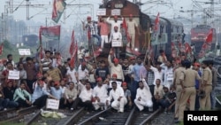 Demonstrators from the Samajwadi Party, a regional political party, shout slogans after they stopped a passenger train during a protest near Allahabad railway station, September 20, 2012. 