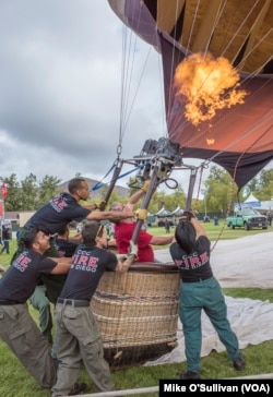 Volunteers inflate a balloon.