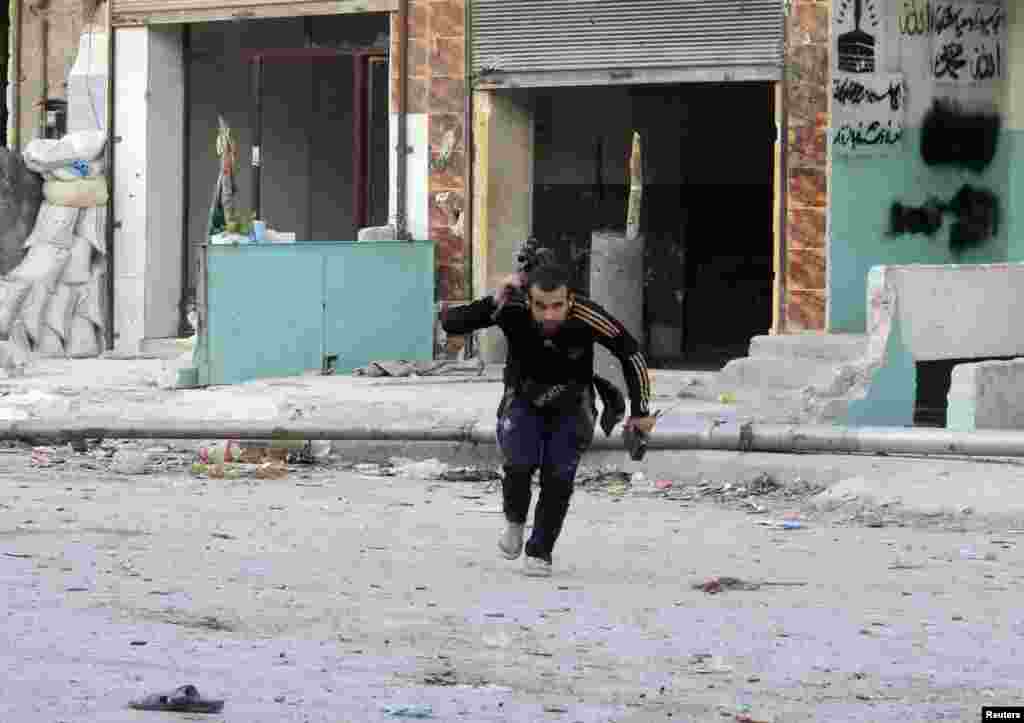 A Free Syrian Army fighter carries his weapon as he runs to avoid snipers loyal to Syria's President Bashar al-Assad in Aleppo, Oct. 1, 2013. 