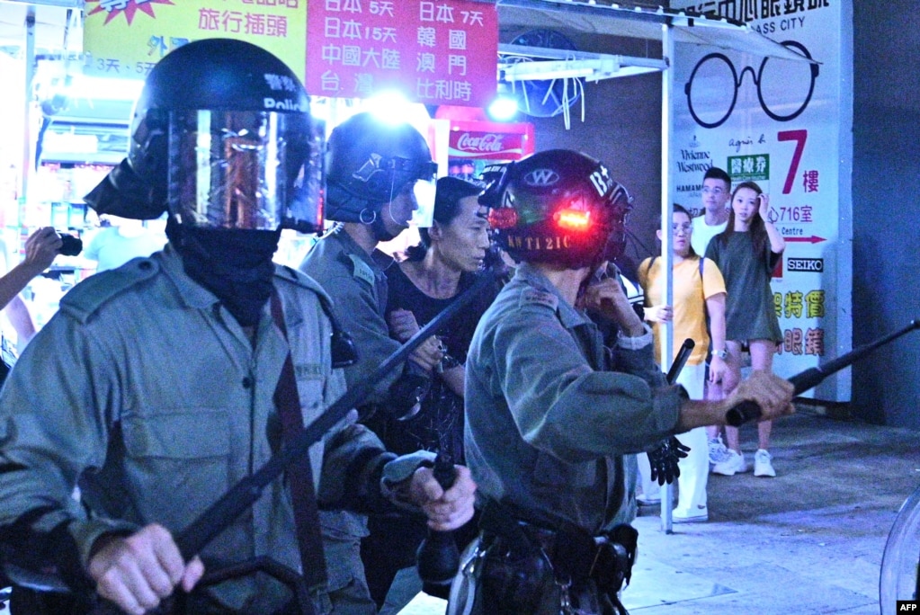《好莱坞报道》的文章说，对于香港的暴力镇压抗议，好莱坞一直保持沉默。图为一名身份不明的男子在香港一次集会后被防暴警察带走。(2019年10月5日)(photo:VOA)